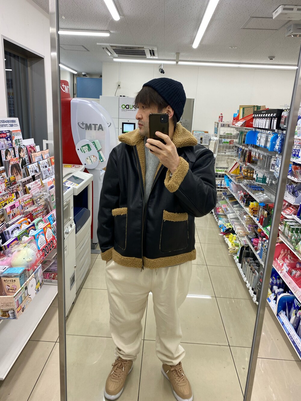 ブラック系のブルゾン、グレー系のスウェット、ホワイト系のスラックスを着用したメンズの冬コーディネートの3枚目の写真