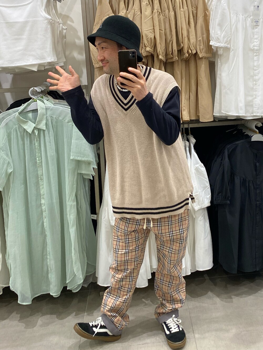 ベージュ系のベスト、ベージュ系のパンツ、ブラック系のスニーカーを着用したメンズの春コーディネートの4枚目の写真