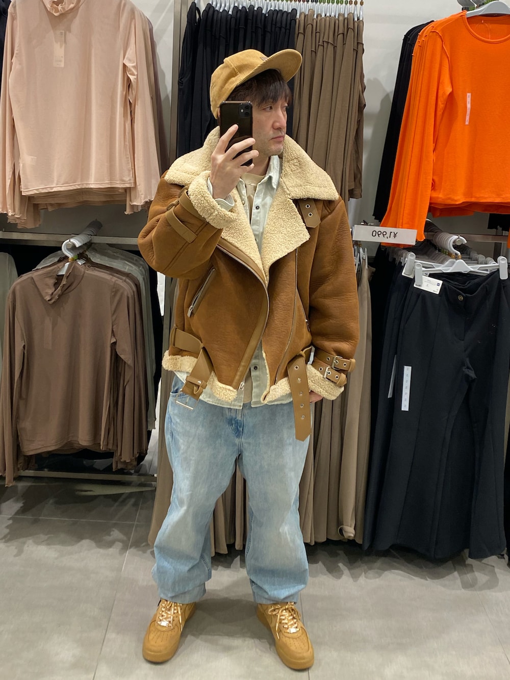 ブルー系のシャツ/ブラウス、ブラウン系のムートンコート、ブルー系のデニムパンツを着用したメンズの冬コーディネートの2枚目の写真