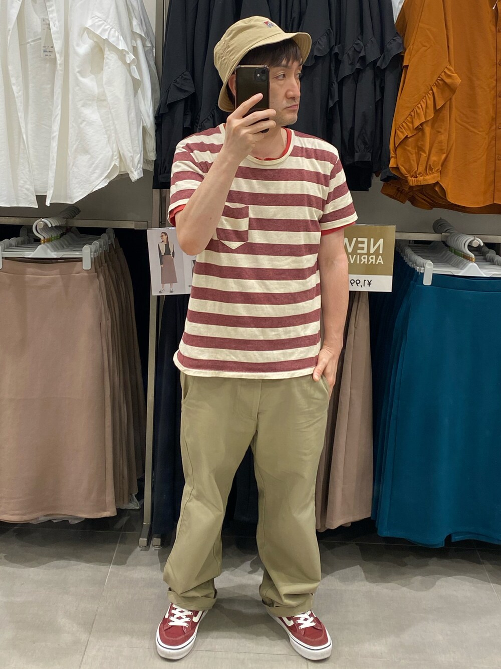 ベージュ系のチノパンツ、レッド系のスニーカー、その他のTシャツ/カットソーを着用したメンズの夏コーディネートの2枚目の写真