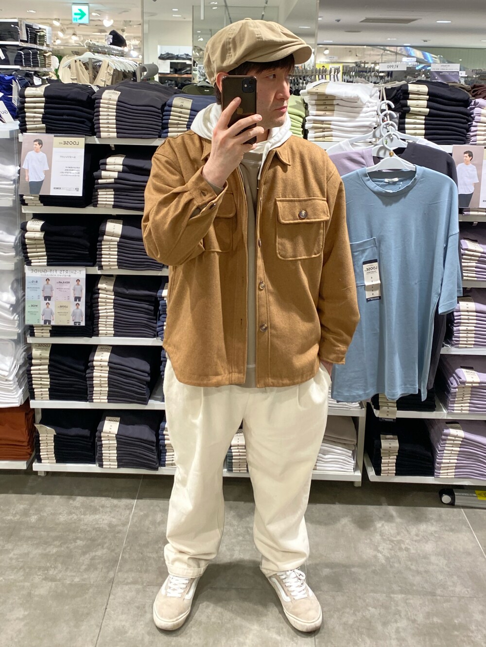 ホワイト系のスラックス、イエロー系のカバーオール、ベージュ系のスニーカーを着用したメンズの春コーディネートの2枚目の写真