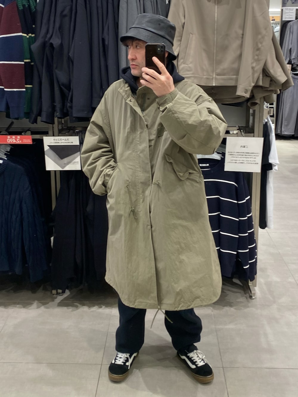 ブラック系のスニーカー、ブラック系のパーカー、グリーン系のモッズコートを着用したメンズの冬コーディネートの2枚目の写真