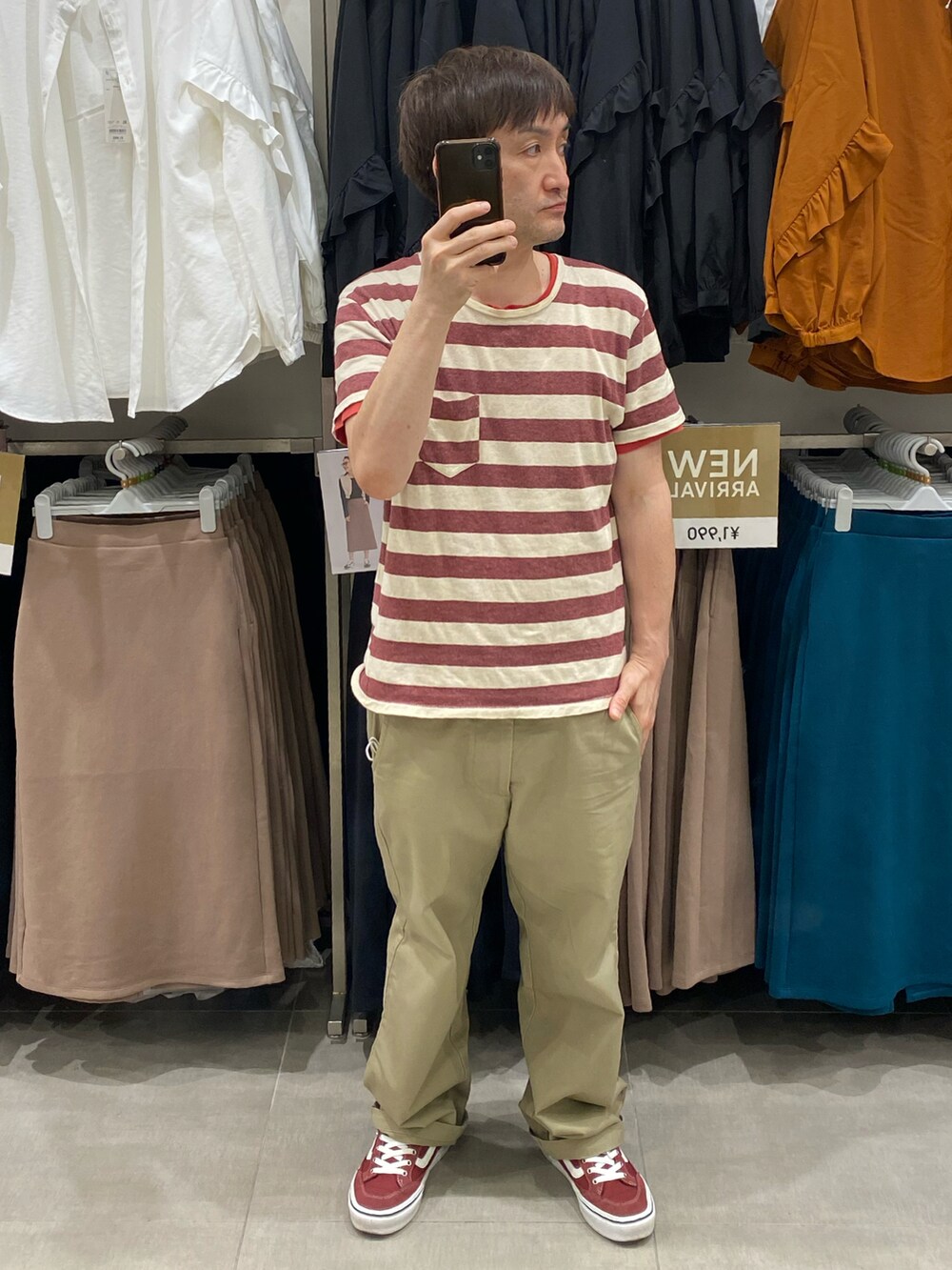 ベージュ系のチノパンツ、レッド系のスニーカー、その他のTシャツ/カットソーを着用したメンズの夏コーディネートの3枚目の写真