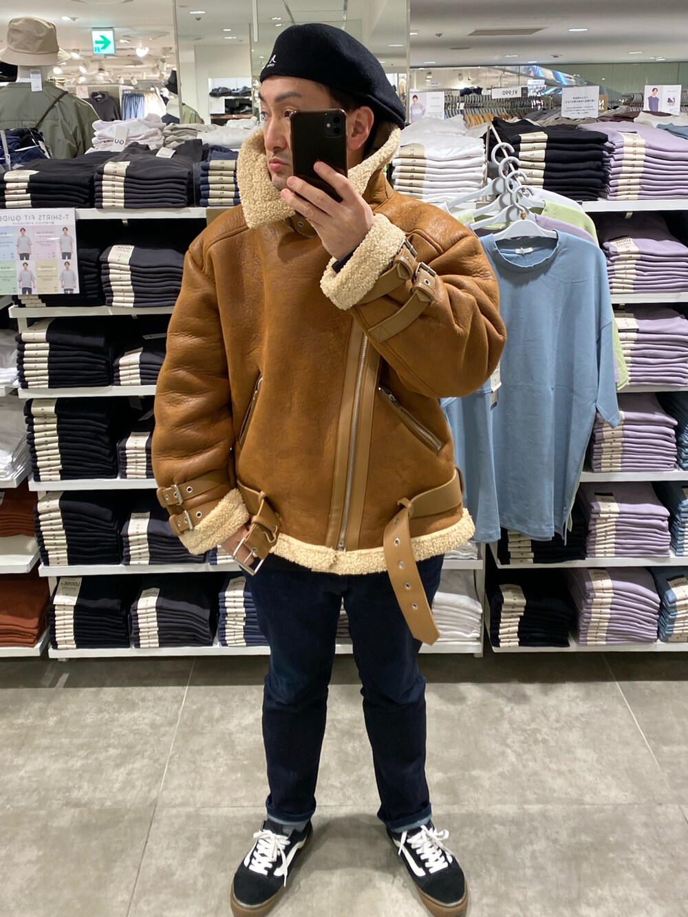 ブラウン系のムートンコート、ブルー系のデニムパンツ、ブラック系のスニーカーを着用したメンズの冬コーディネートの3枚目の写真