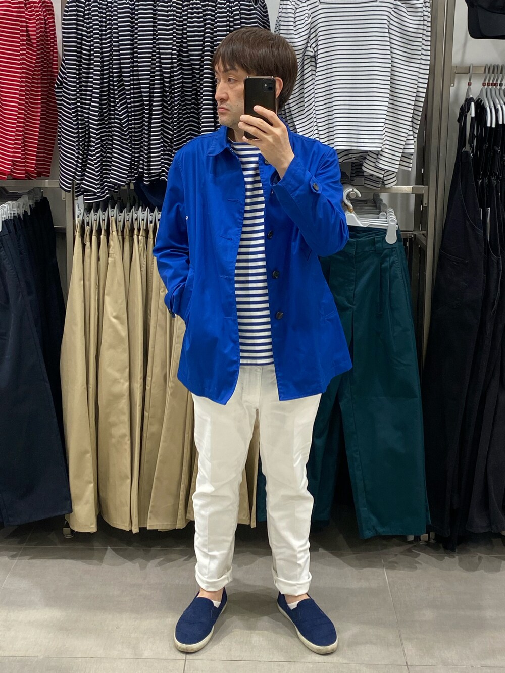 ブルー系のステンカラーコート、ブルー系のステンカラーコート、ホワイト系のデニムパンツを着用したメンズの春コーディネートの3枚目の写真