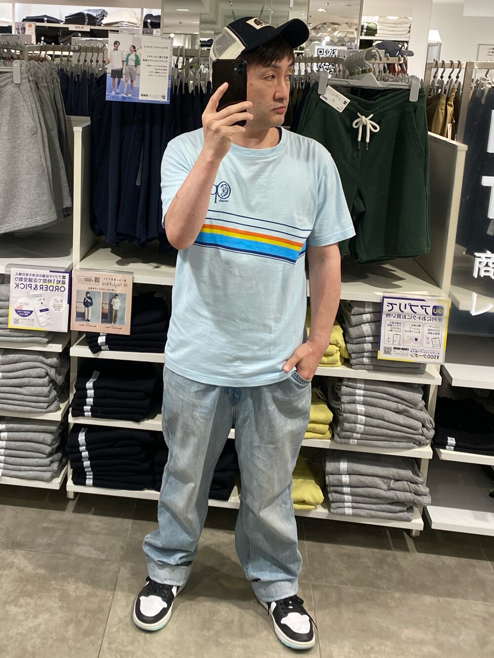 ブルー系のデニムパンツ、ブルー系のTシャツ/カットソー、ホワイト系のスニーカーを着用したメンズの夏コーディネートの2枚目の写真