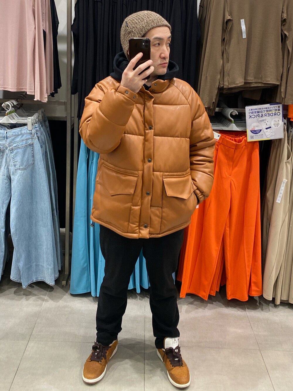 ブラウン系のダウンジャケット/コート、ブラック系のその他パンツ、ブラウン系のスニーカーを着用したメンズの春コーディネートの2枚目の写真