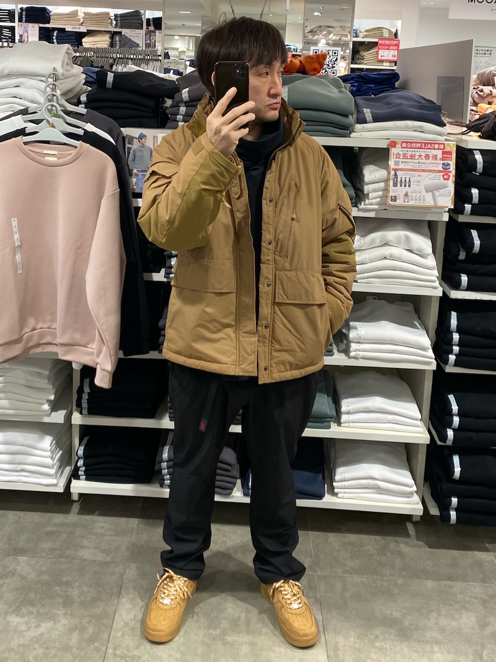 ベージュ系のダウンジャケット/コート、ブラック系のその他パンツ、ブラウン系のスニーカーを着用したメンズの冬コーディネートの3枚目の写真