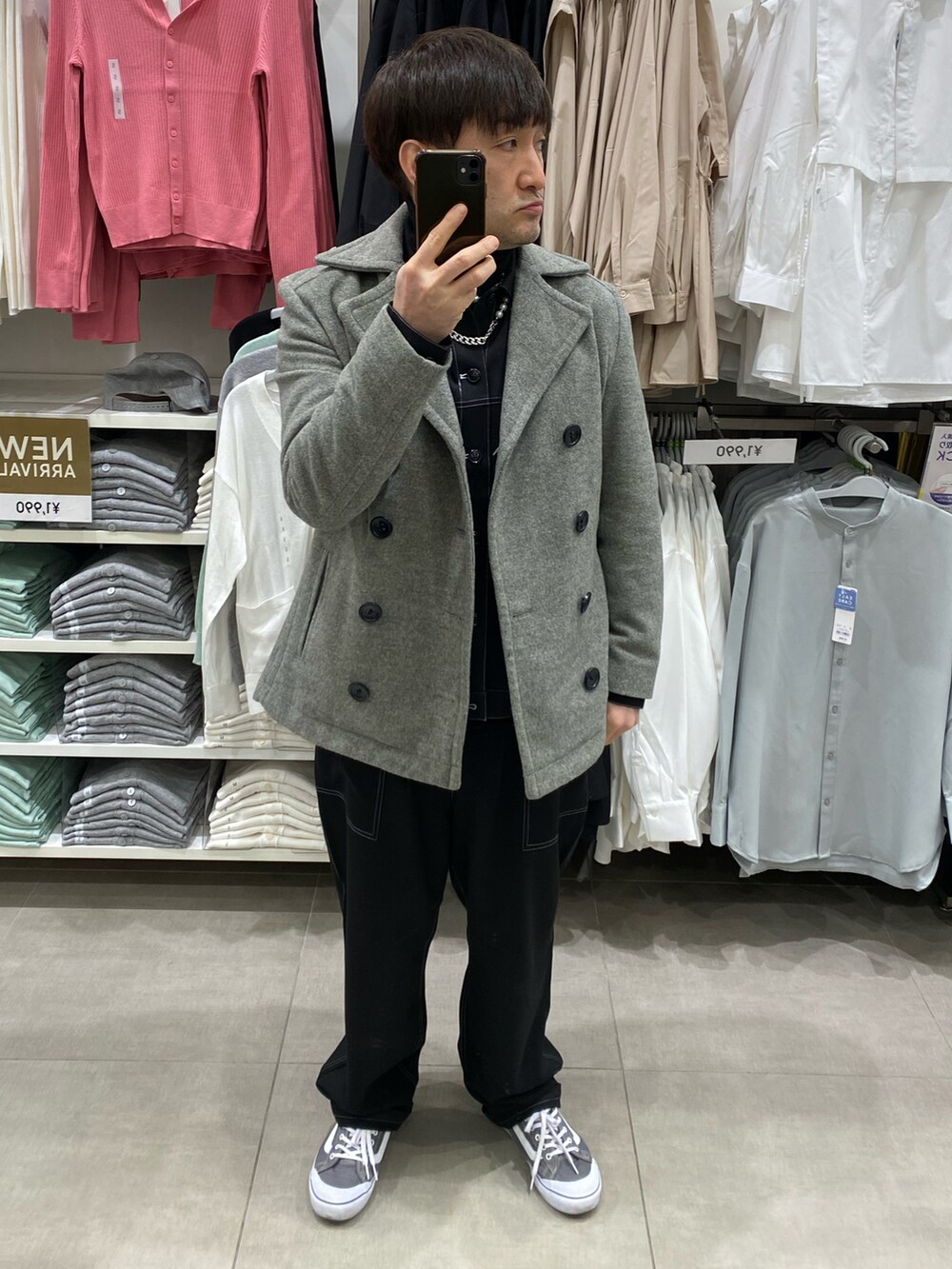 グレー系のピーコート、グレー系のスニーカー、ブラック系のTシャツ/カットソーを着用したメンズの冬コーディネートの3枚目の写真
