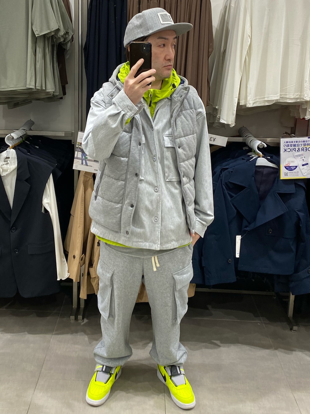 グレー系のダウンベスト、グレー系のカバーオール、グレー系のスウェットパンツを着用したメンズの春コーディネートの4枚目の写真