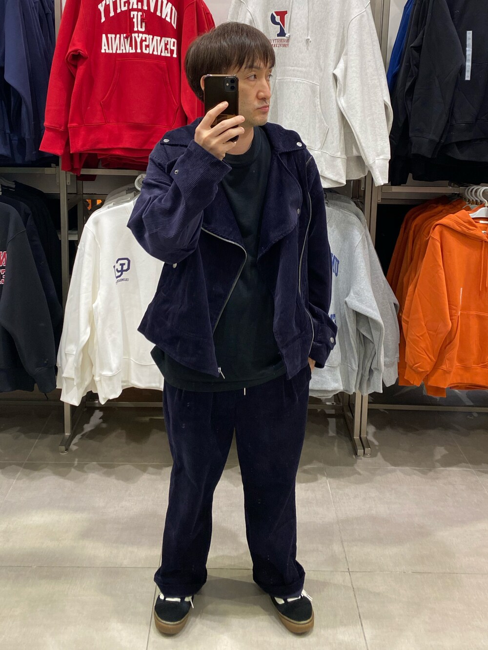 ブルー系のライダースジャケット、ブラック系のショルダーバッグ、ブラック系のスニーカーを着用したメンズの秋コーディネートの5枚目の写真