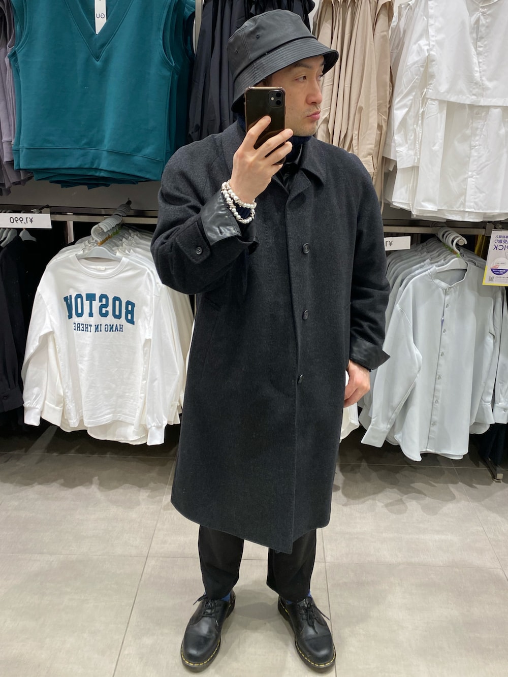 グレー系のステンカラーコート、ブラック系のスウェットパンツ、ブラック系のドレスシューズを着用したメンズの冬コーディネートの4枚目の写真