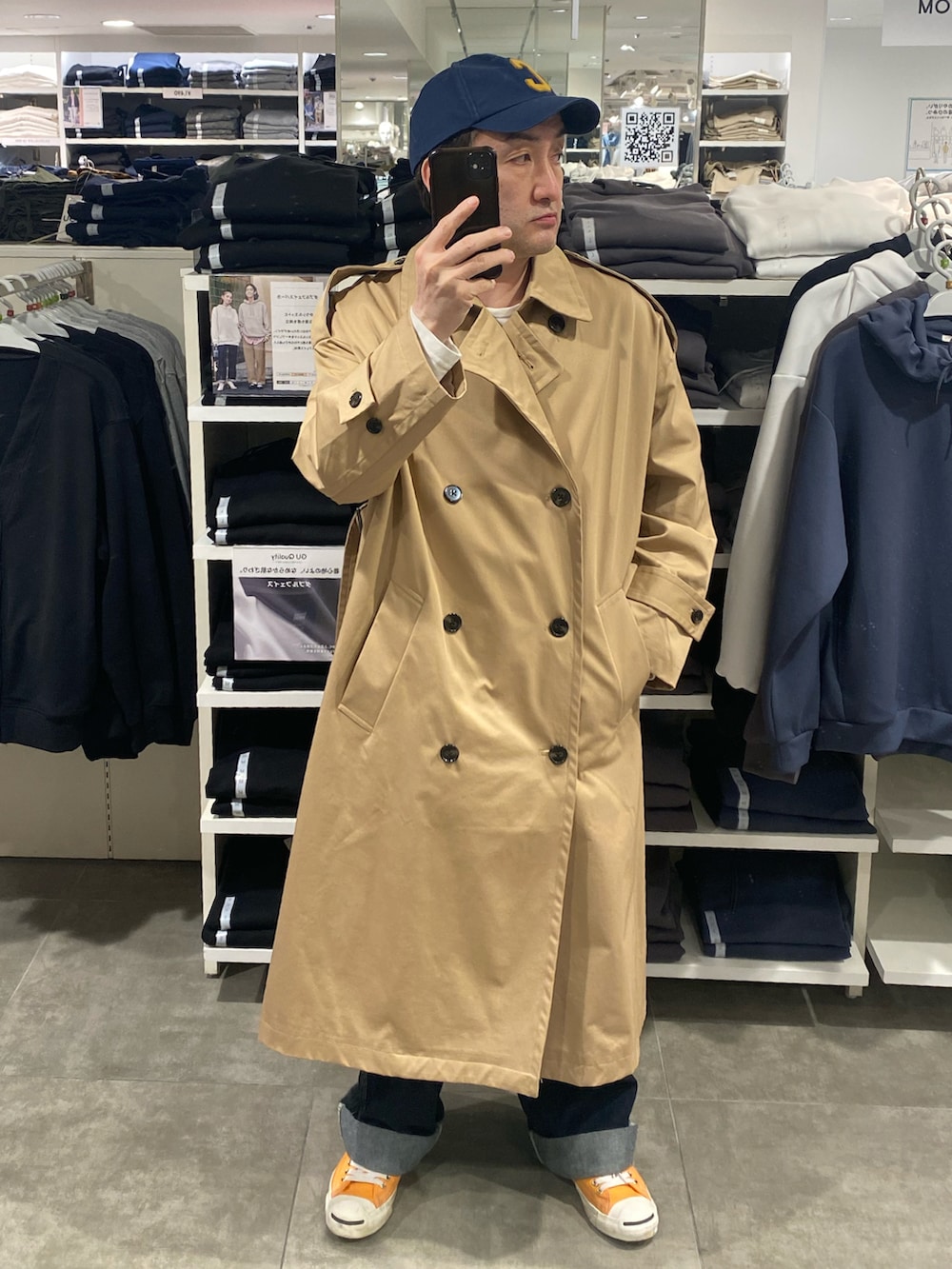 ベージュ系のトレンチコート、ブルー系のカーゴパンツ、オレンジ系のスニーカーを着用したメンズの春コーディネートの4枚目の写真