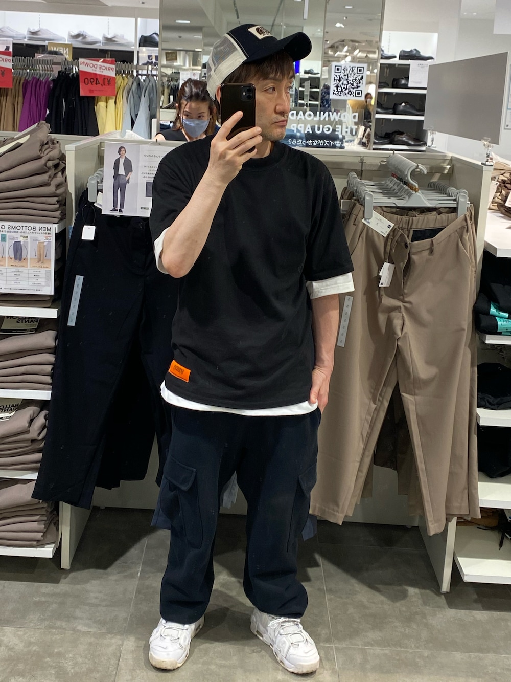 ブラック系のTシャツ/カットソー、ブラック系のカーゴパンツ、ホワイト系のスニーカーを着用したメンズの夏コーディネートの2枚目の写真