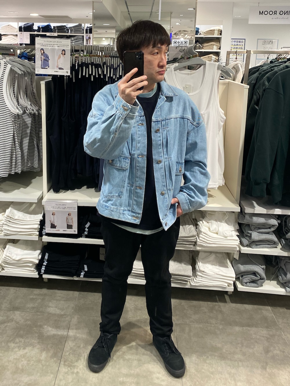 ブルー系のデニムジャケット、ブラック系のパンツ、ブラック系のスニーカーを着用したメンズの春コーディネートの5枚目の写真