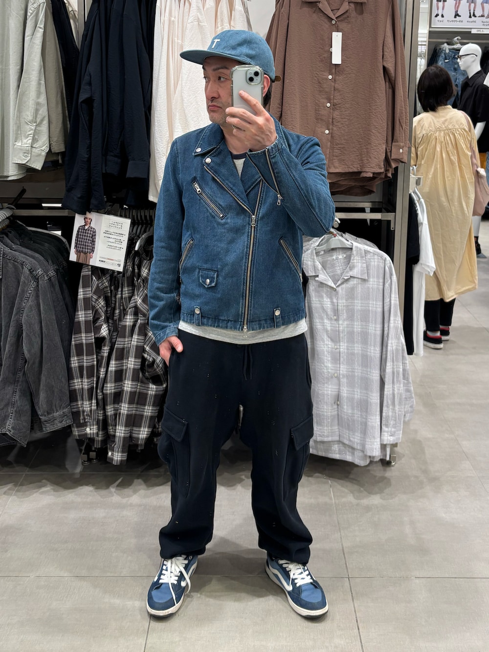 ブルー系のライダースジャケット、ブラック系のスウェットパンツ、ブルー系のキャップを着用したメンズの冬コーディネートの2枚目の写真