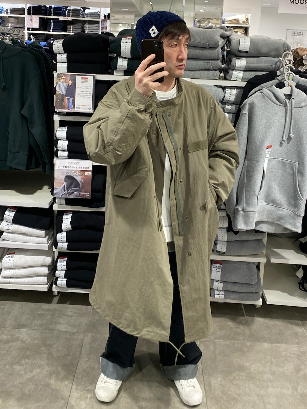 ホワイト系のスウェット、グリーン系のモッズコート、ブルー系のカーゴパンツを着用したメンズの冬コーディネートの2枚目の写真
