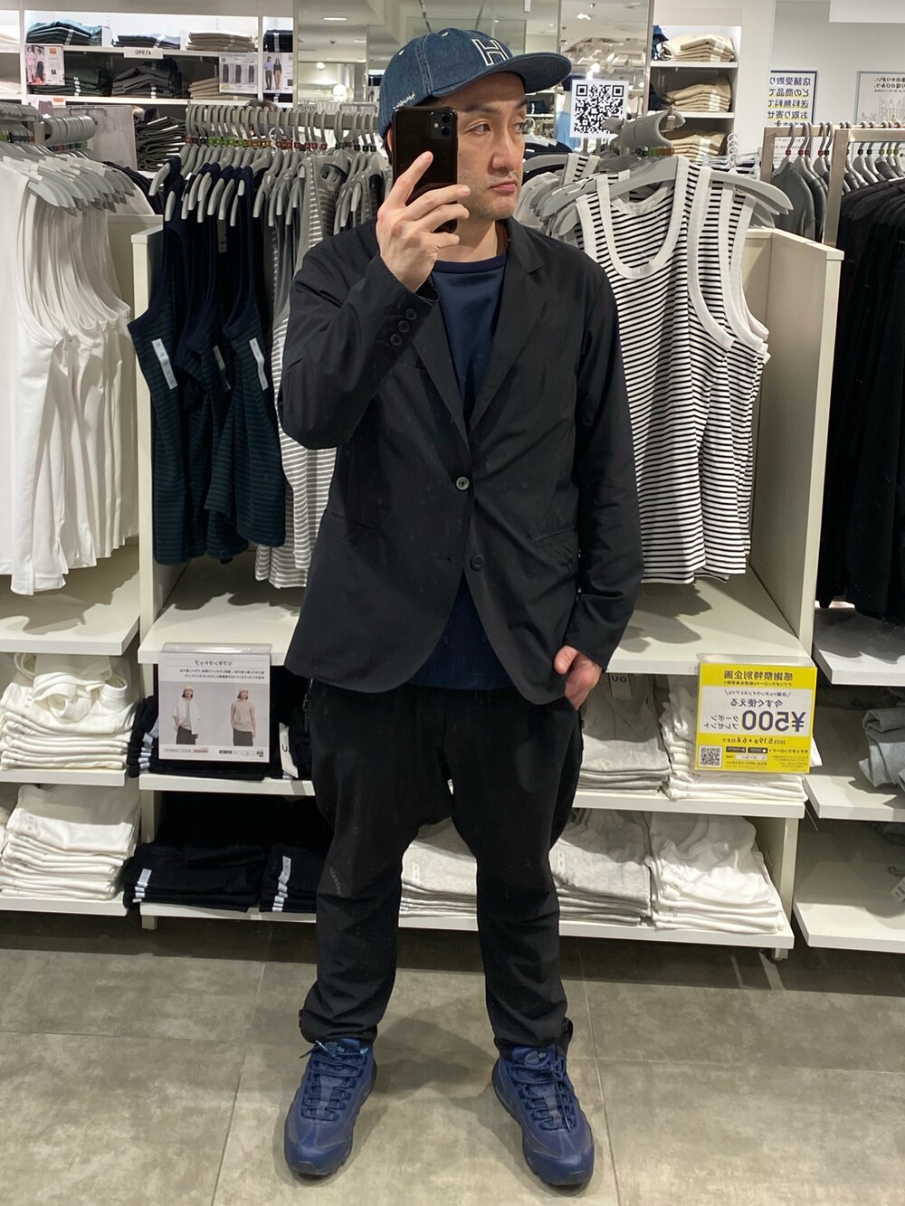 ブラック系のテーラードジャケット、ブラック系のその他パンツ、ブルー系のスニーカーを着用したメンズの春コーディネートの4枚目の写真