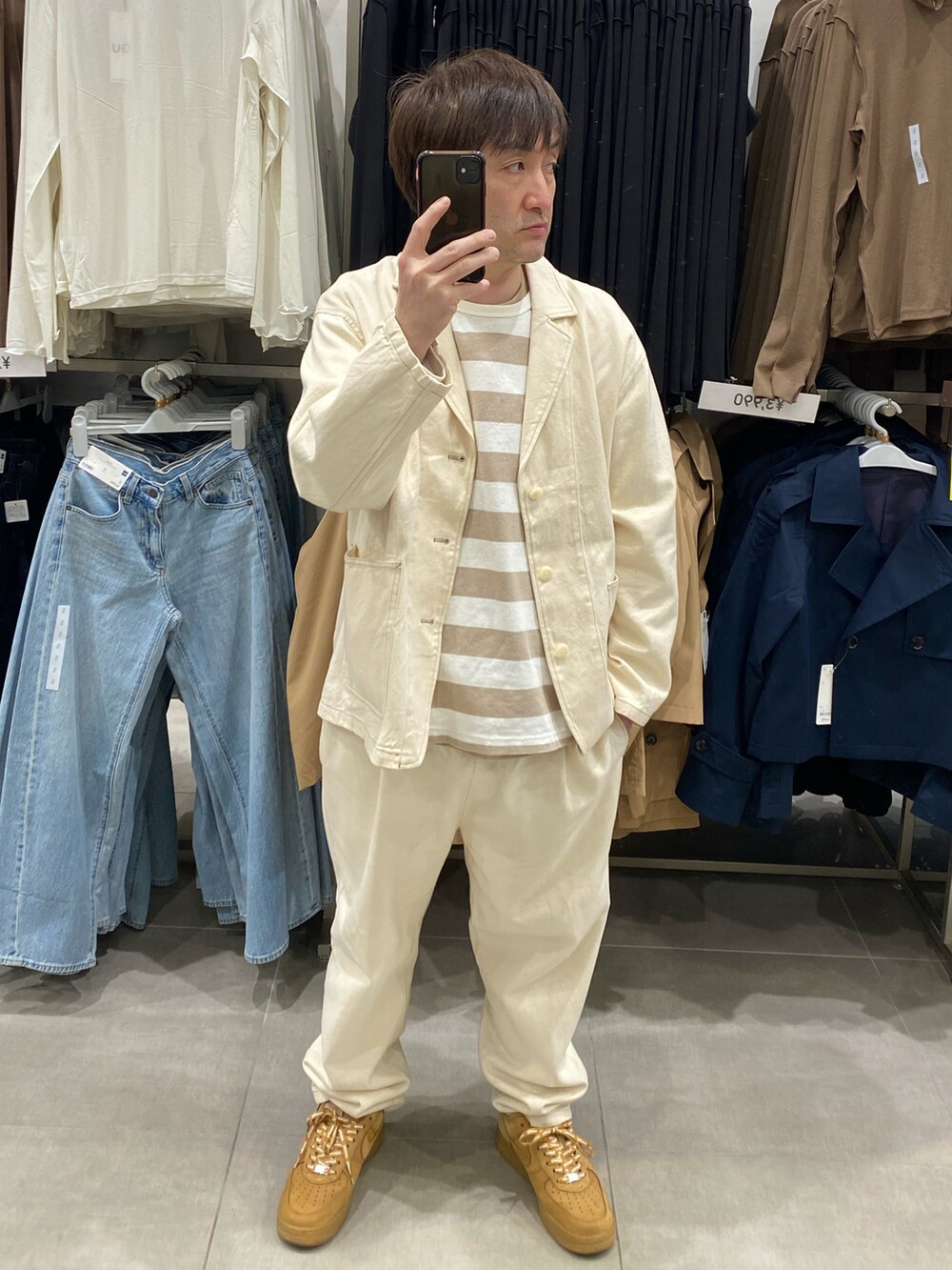 ホワイト系のテーラードジャケット、ホワイト系のスラックス、ブラウン系のスニーカーを着用したメンズの春コーディネートの4枚目の写真