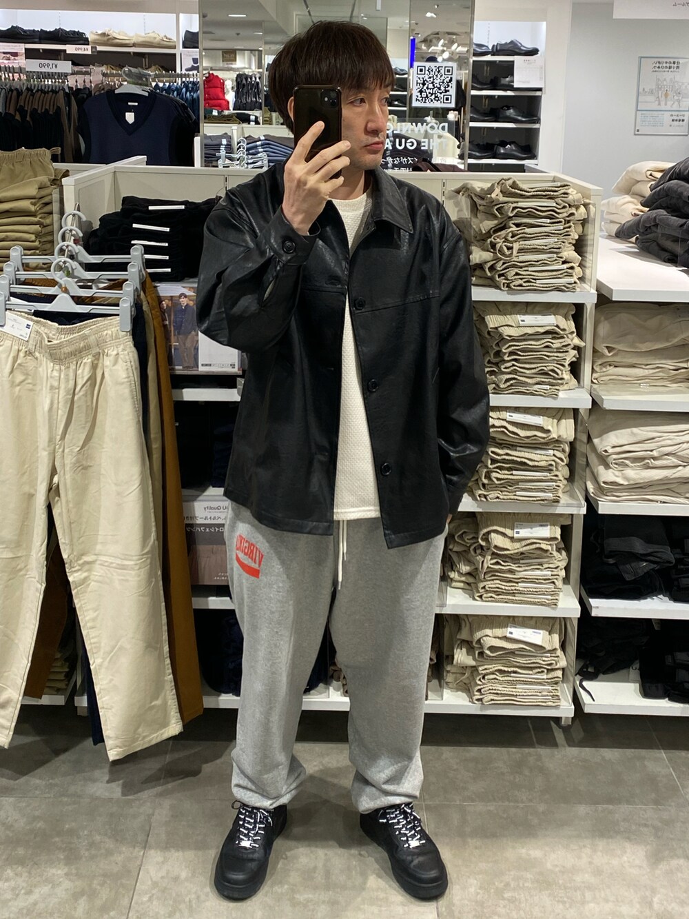 ブラック系のジャケット/アウター、ホワイト系のニット/セーター、グレー系のスウェットパンツを着用したメンズの秋コーディネートの5枚目の写真