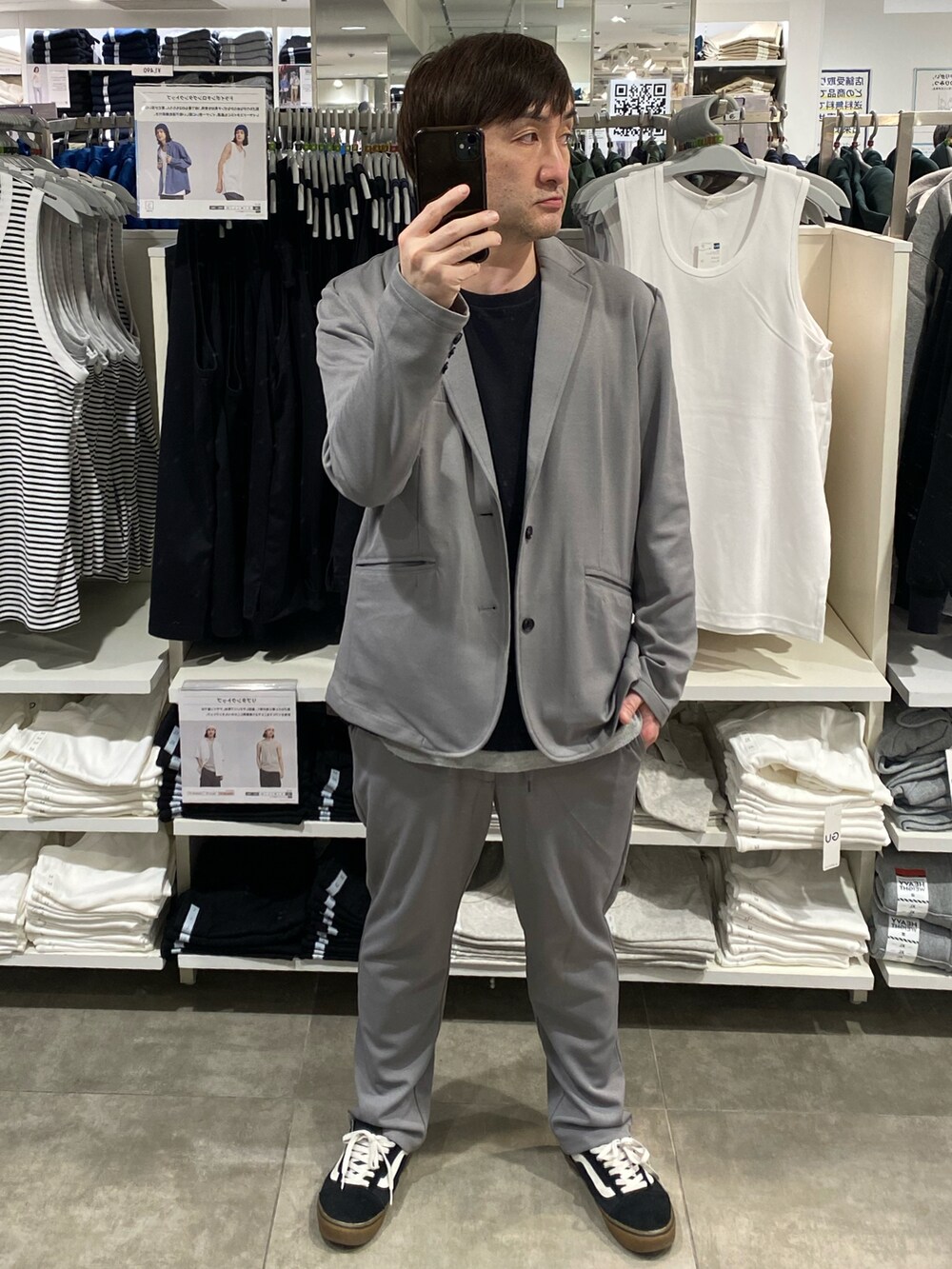 グレー系のセットアップ、ブラック系のTシャツ/カットソー、ブラック系のスニーカーを着用したメンズの春コーディネートの3枚目の写真