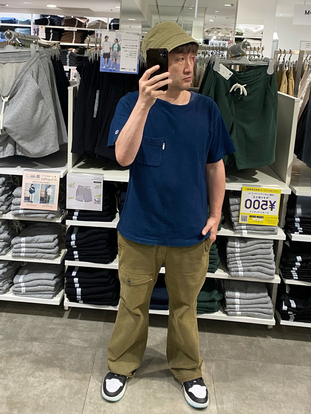 ブルー系のTシャツ/カットソー、グリーン系のカーゴパンツ、ホワイト系のスニーカーを着用したメンズの夏コーディネートの2枚目の写真