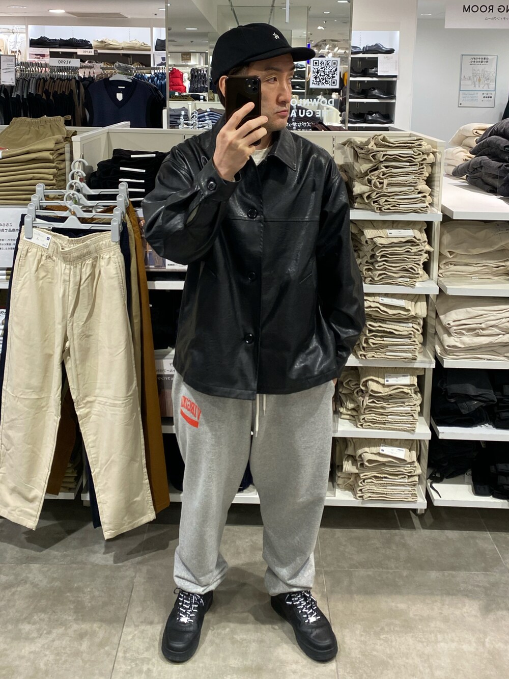 ブラック系のジャケット/アウター、ホワイト系のニット/セーター、グレー系のスウェットパンツを着用したメンズの秋コーディネートの2枚目の写真