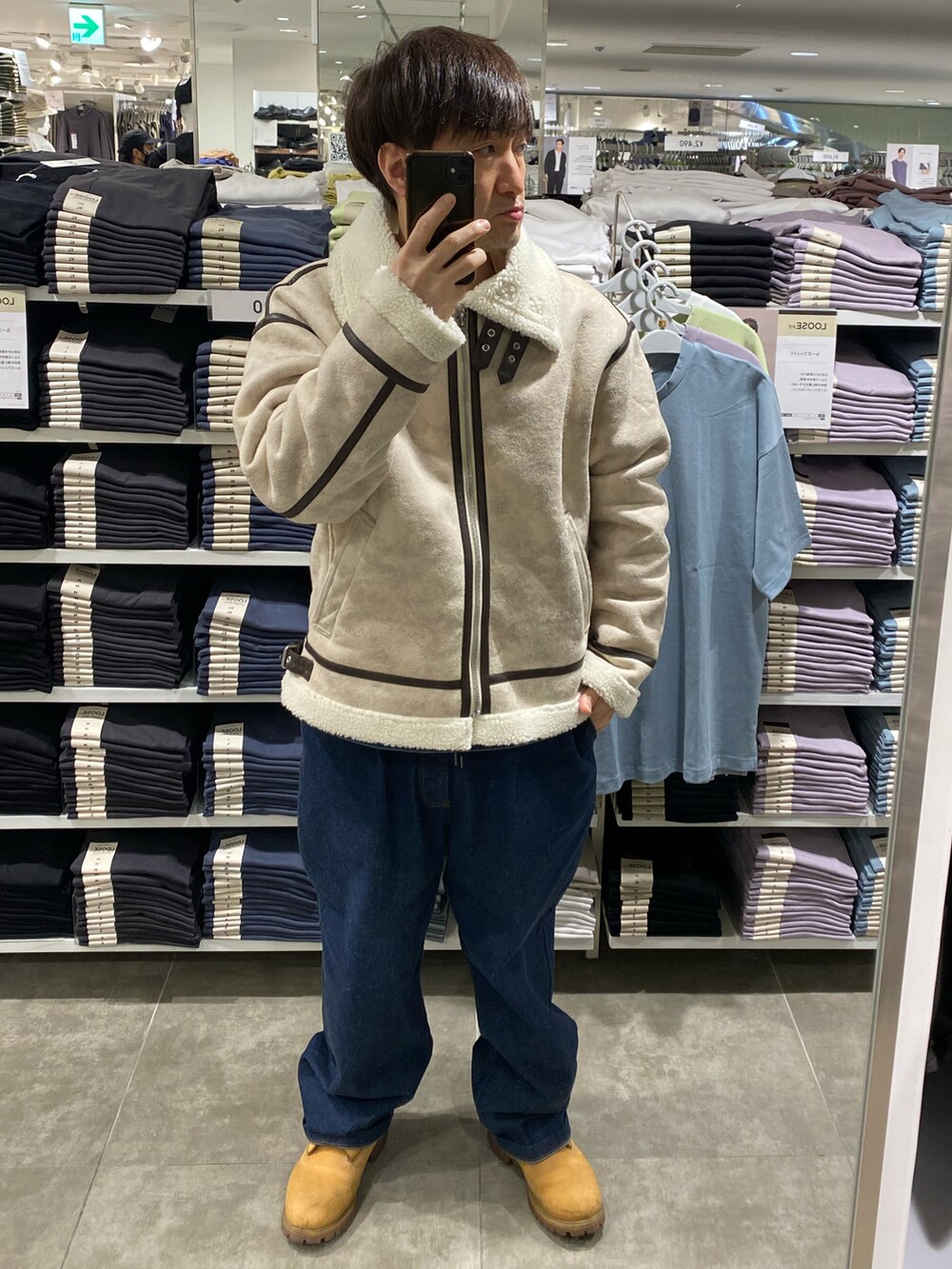ホワイト系のブルゾン、ブルー系のデニムパンツ、ベージュ系のブーツを着用したメンズの冬コーディネートの4枚目の写真