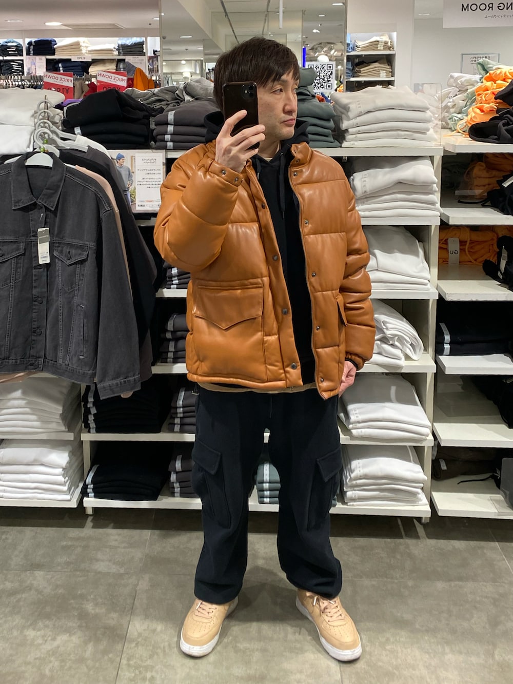 ブラウン系のダウンジャケット/コート、ブラック系のカーゴパンツ、ベージュ系のスニーカーを着用したメンズの冬コーディネートの3枚目の写真