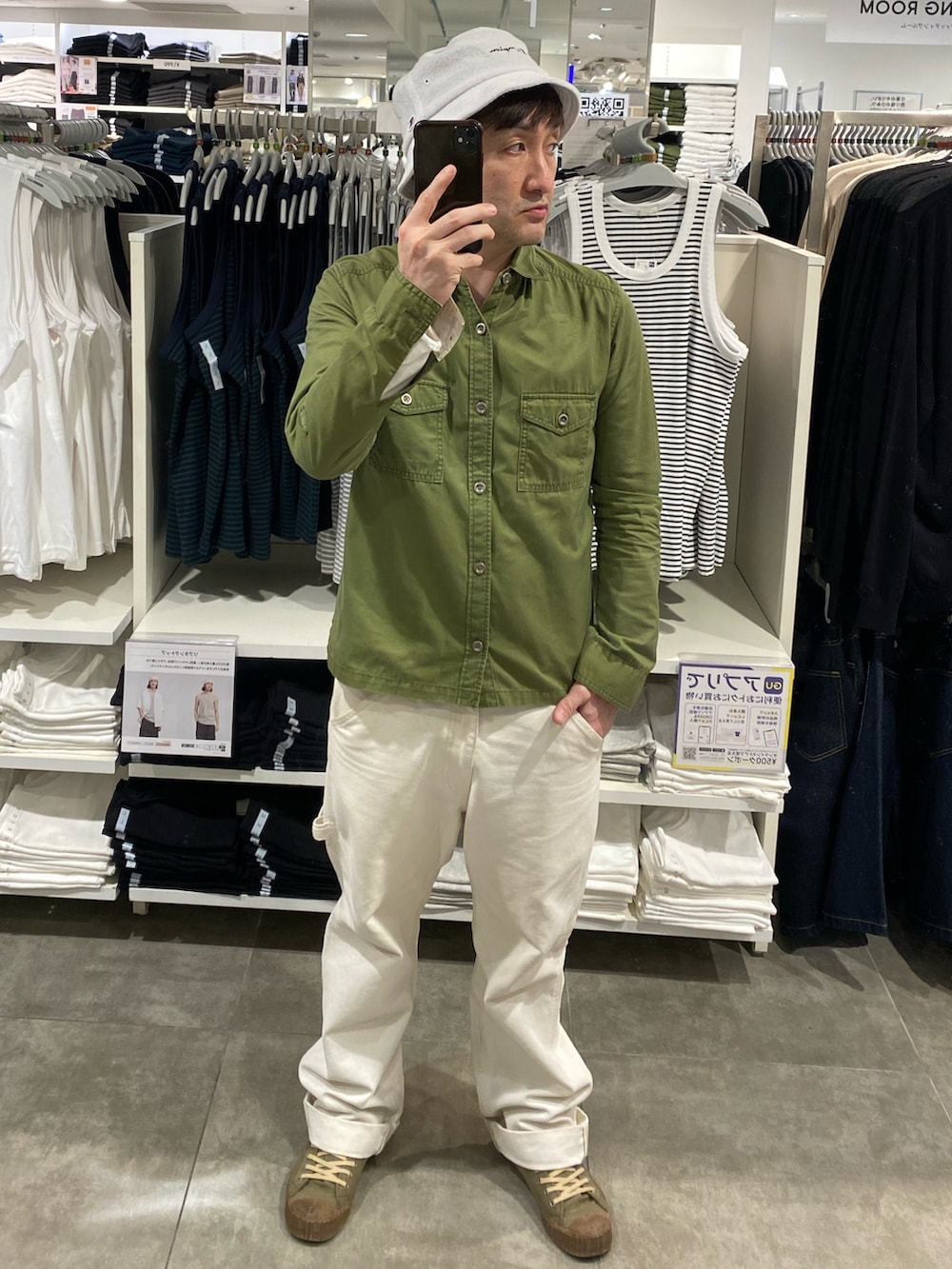 ホワイト系のカーゴパンツ、グリーン系のスニーカー、ホワイト系のハットを着用したメンズの夏コーディネートの2枚目の写真