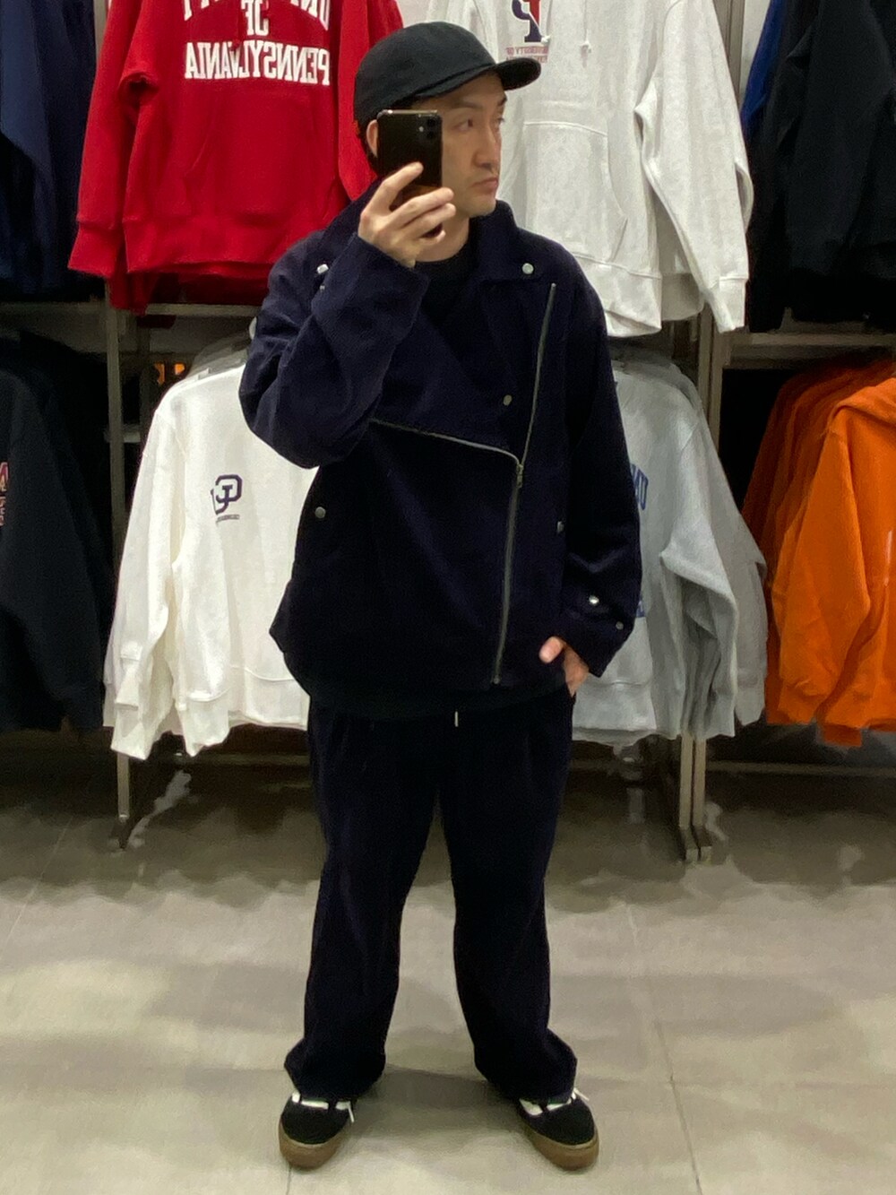 ブルー系のライダースジャケット、ブラック系のショルダーバッグ、ブラック系のスニーカーを着用したメンズの秋コーディネートの2枚目の写真