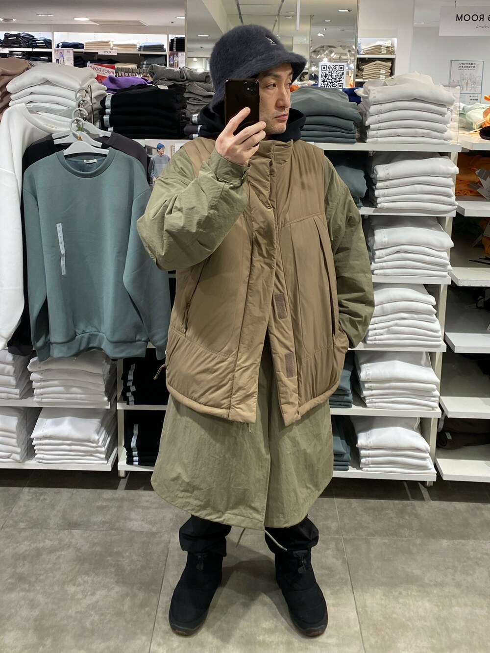 ブラウン系のダウンベスト、グリーン系のモッズコート、ブラック系のブーツを着用したメンズの冬コーディネートの4枚目の写真