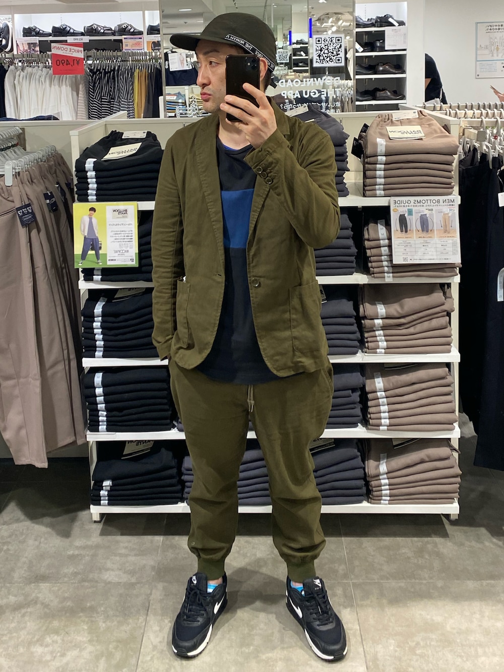 グリーン系のセットアップ、ブラック系のスニーカー、ブラック系のTシャツ/カットソーを着用したメンズの春コーディネートの3枚目の写真