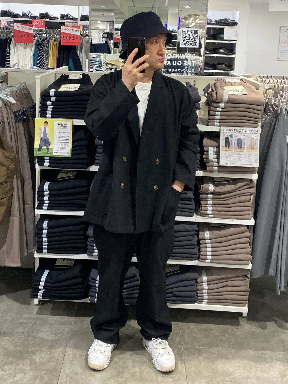 ブラック系のテーラードジャケット、ブラック系のその他パンツ、ホワイト系のスニーカーを着用したメンズの夏コーディネートの3枚目の写真