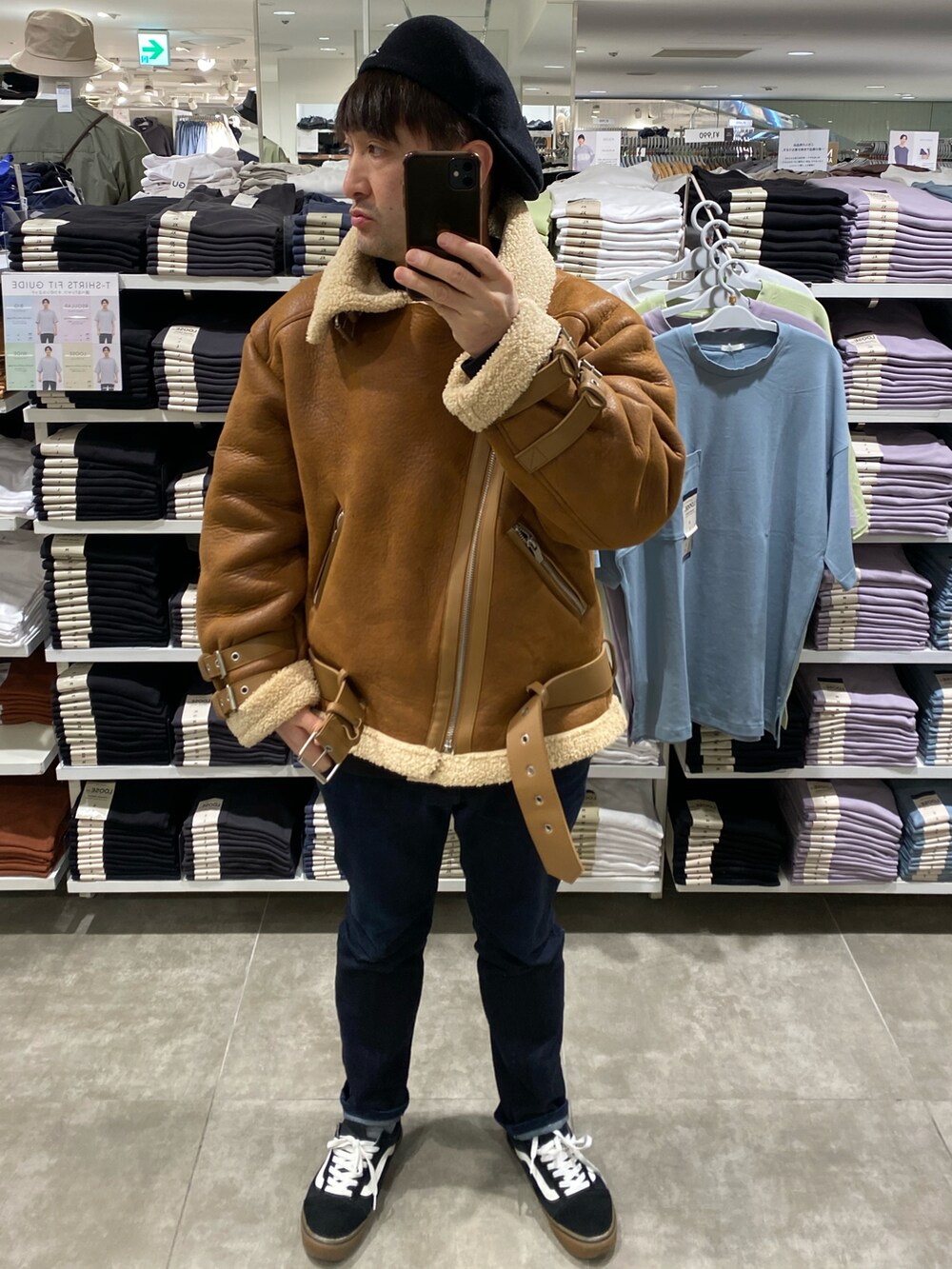ブラウン系のムートンコート、ブルー系のデニムパンツ、ブラック系のスニーカーを着用したメンズの冬コーディネートの4枚目の写真