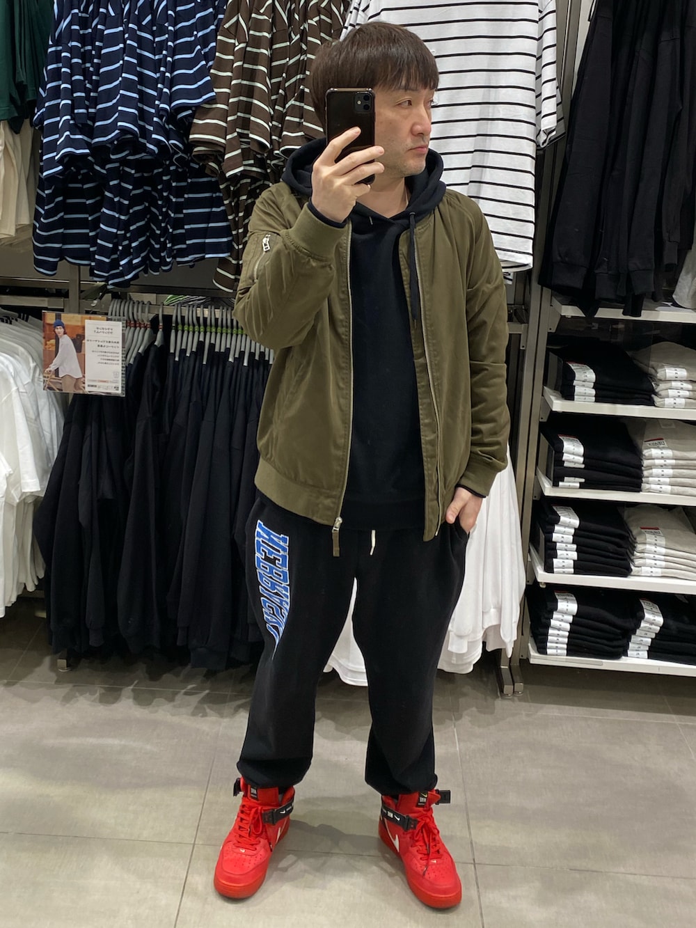 ブラック系のパーカー、グリーン系のMA-1、ブラック系のスウェットパンツを着用したメンズの春コーディネートの3枚目の写真