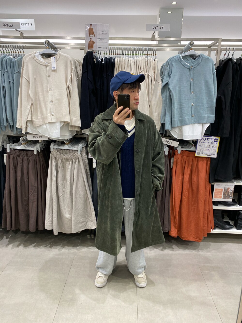 グレー系のスウェットパンツ、ホワイト系のスニーカー、グリーン系のステンカラーコートを着用したメンズの冬コーディネートの2枚目の写真