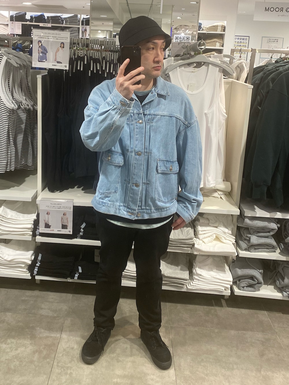 ブルー系のデニムジャケット、ブラック系のパンツ、ブラック系のスニーカーを着用したメンズの春コーディネートの3枚目の写真