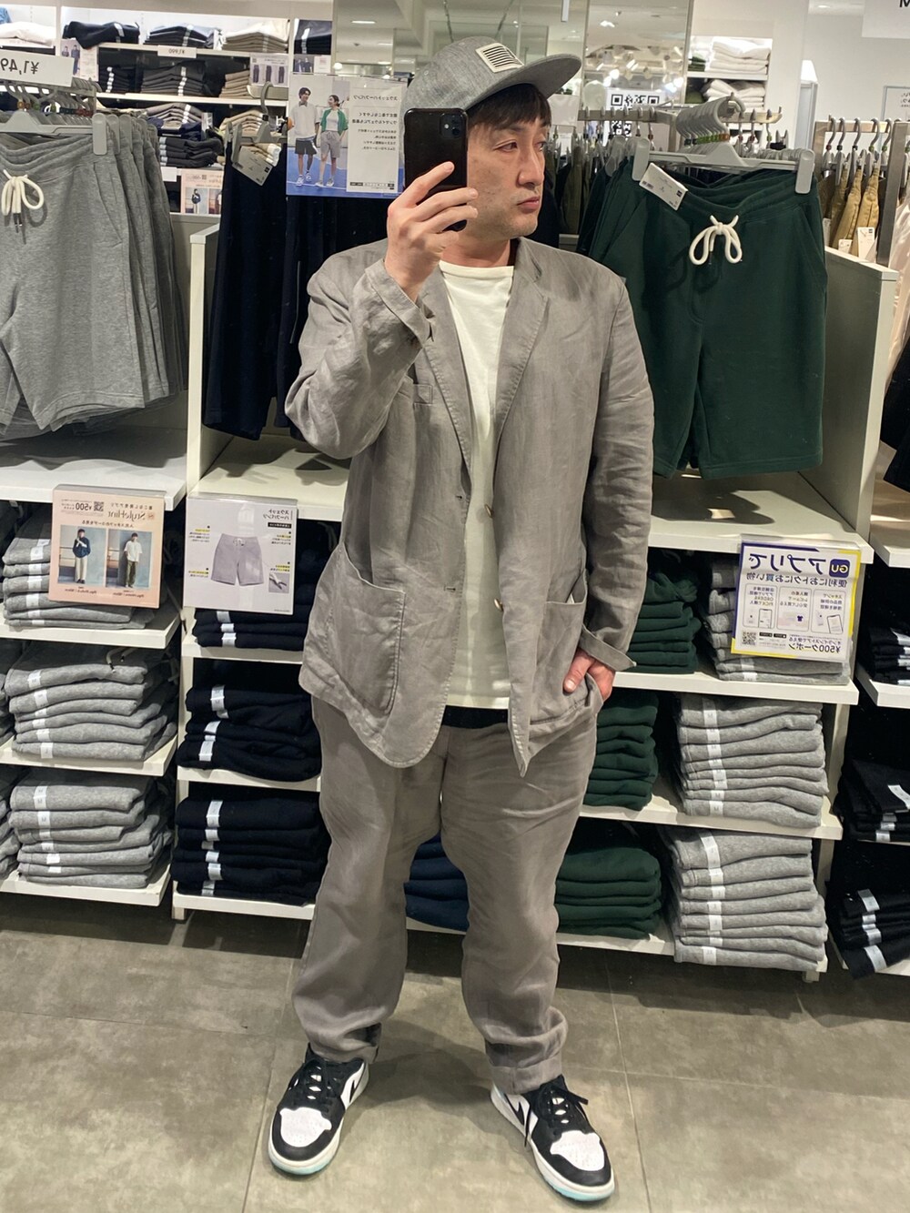 ホワイト系のスニーカー、グレー系のテーラードジャケット、グレー系のその他パンツを着用したメンズの夏コーディネートの2枚目の写真