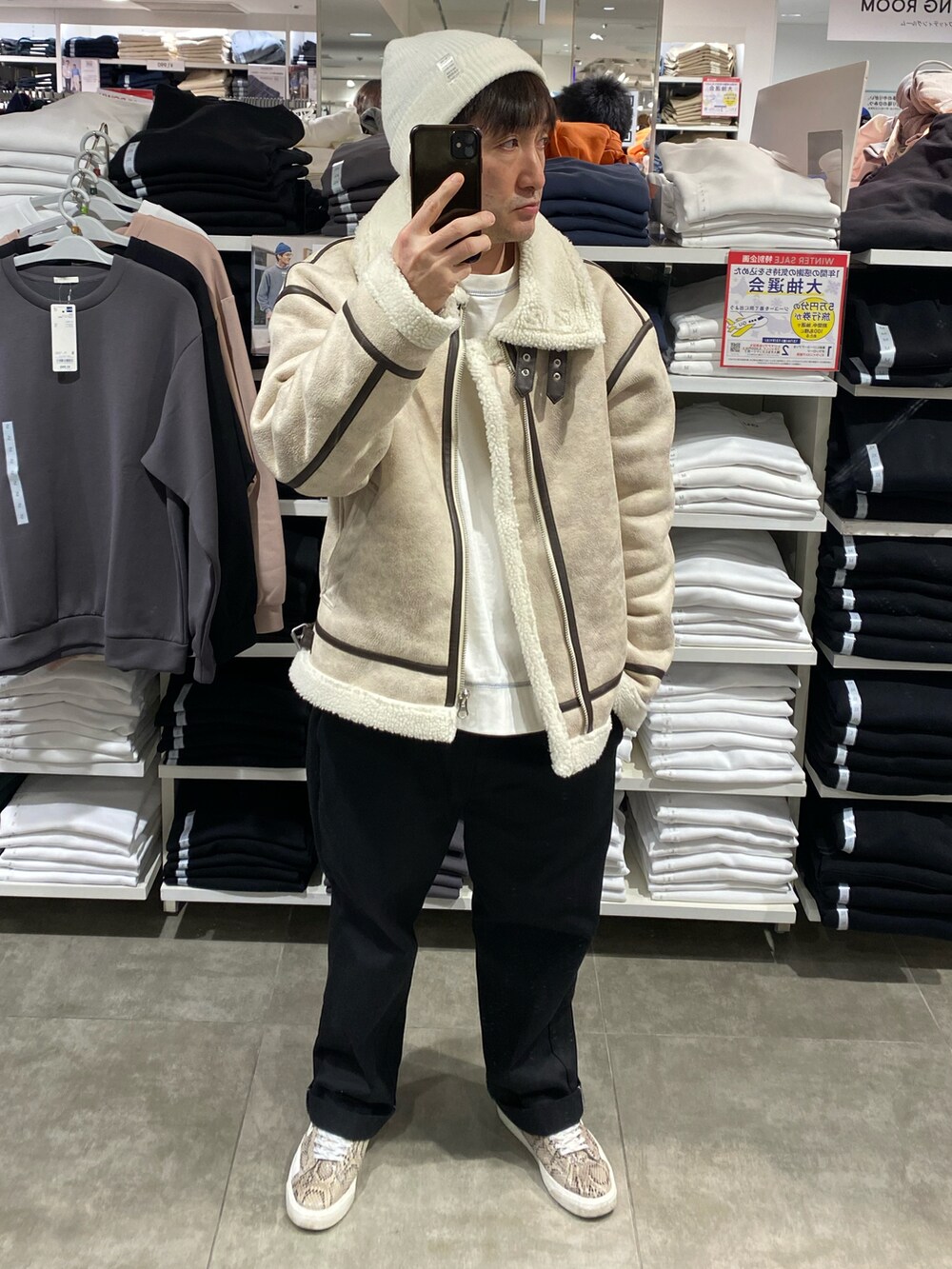 ホワイト系のブルゾン、その他のスニーカー、ブラック系のチノパンツを着用したメンズの冬コーディネートの2枚目の写真