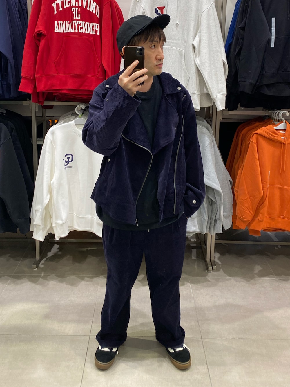 ブルー系のライダースジャケット、ブラック系のショルダーバッグ、ブラック系のスニーカーを着用したメンズの秋コーディネートの4枚目の写真