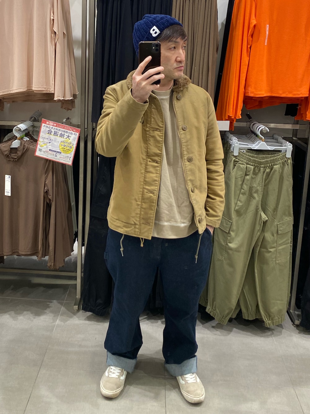 ブラウン系のスウェット、その他のミリタリージャケット、ブルー系のデニムパンツを着用したメンズの冬コーディネートの2枚目の写真