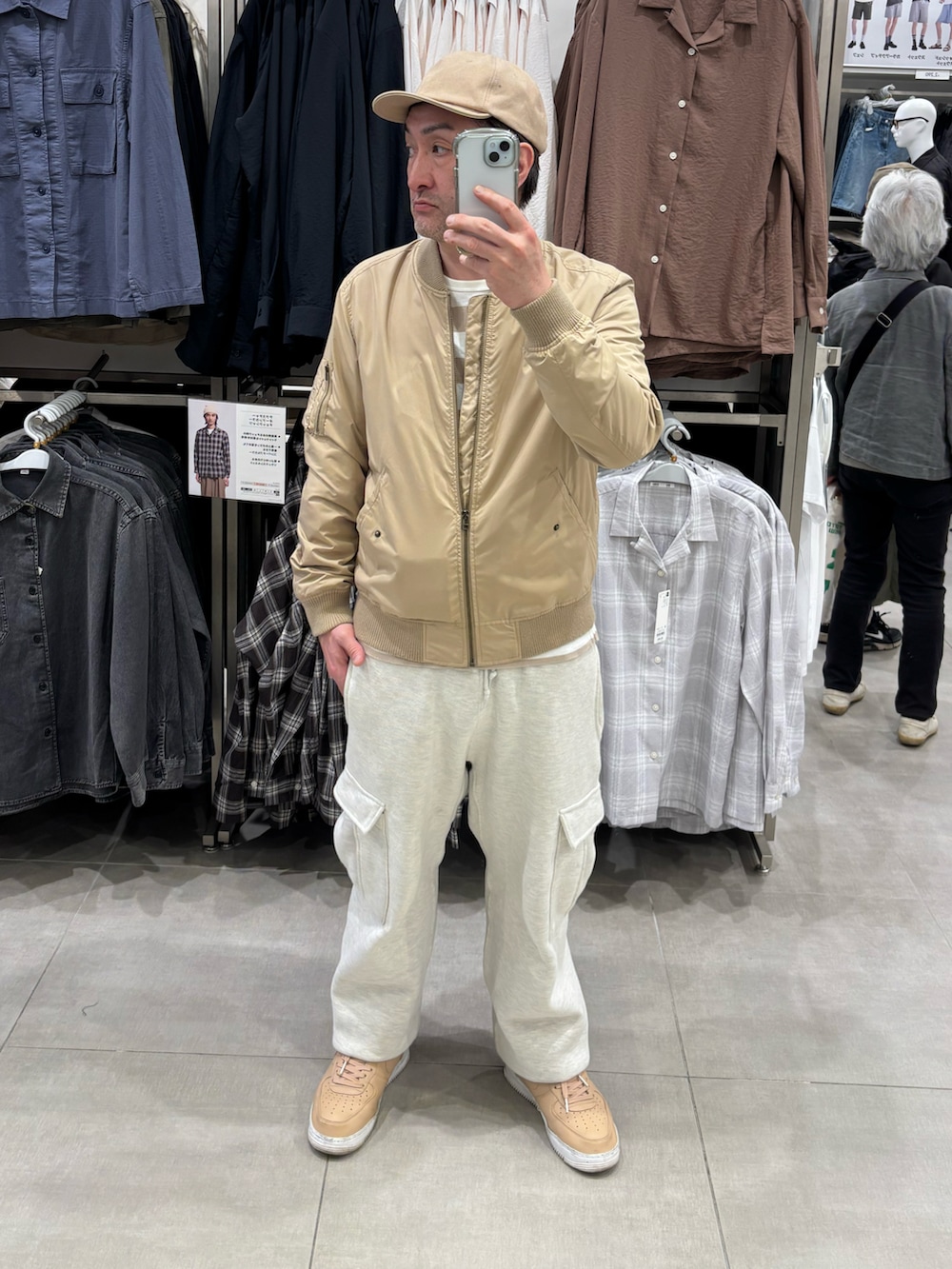 グレー系のカーゴパンツ、ベージュ系のTシャツ/カットソー、ベージュ系のスニーカーを着用したメンズの冬コーディネートの2枚目の写真