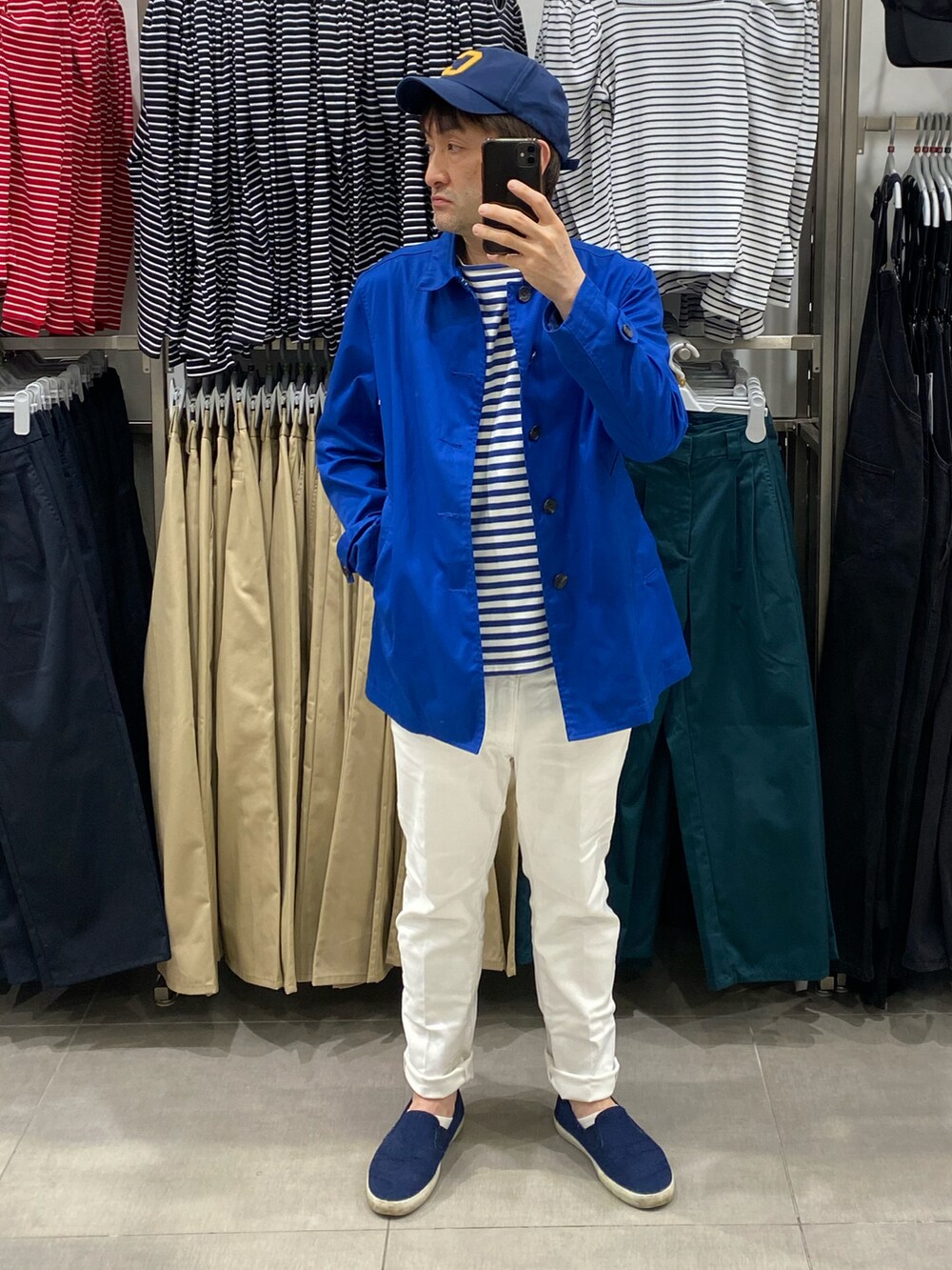 ブルー系のステンカラーコート、ブルー系のステンカラーコート、ホワイト系のデニムパンツを着用したメンズの春コーディネートの4枚目の写真