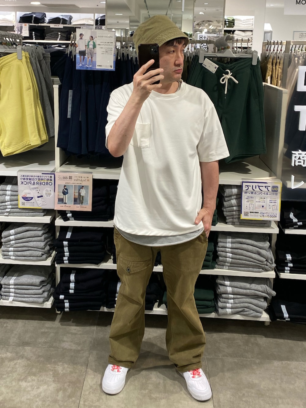 ホワイト系のTシャツ/カットソー、グリーン系のカーゴパンツ、ホワイト系のスニーカーを着用したメンズの夏コーディネートの2枚目の写真