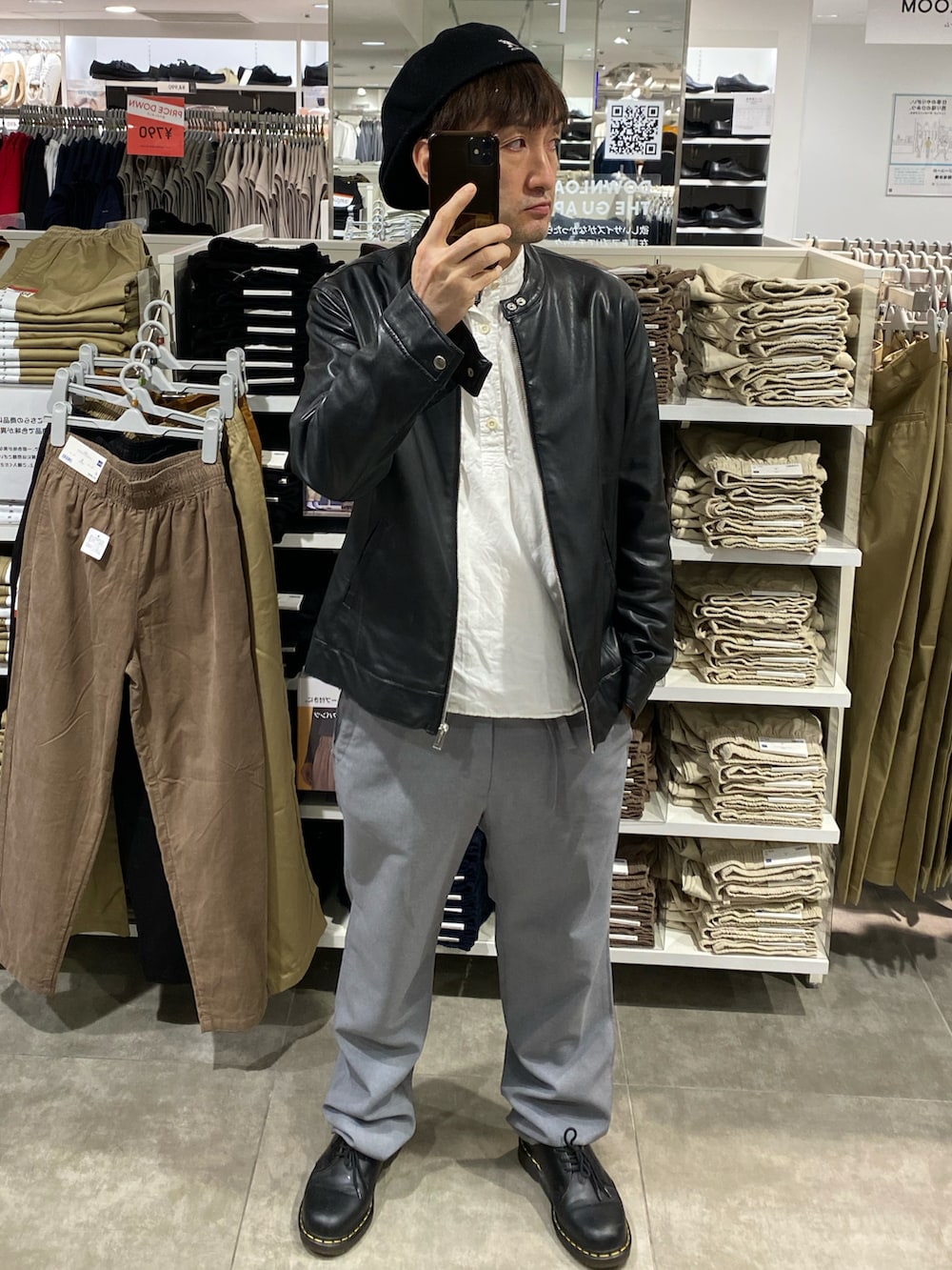 ブラック系のライダースジャケット、ブラック系のショルダーバッグ、グレー系のスラックスを着用したメンズの秋コーディネートの4枚目の写真