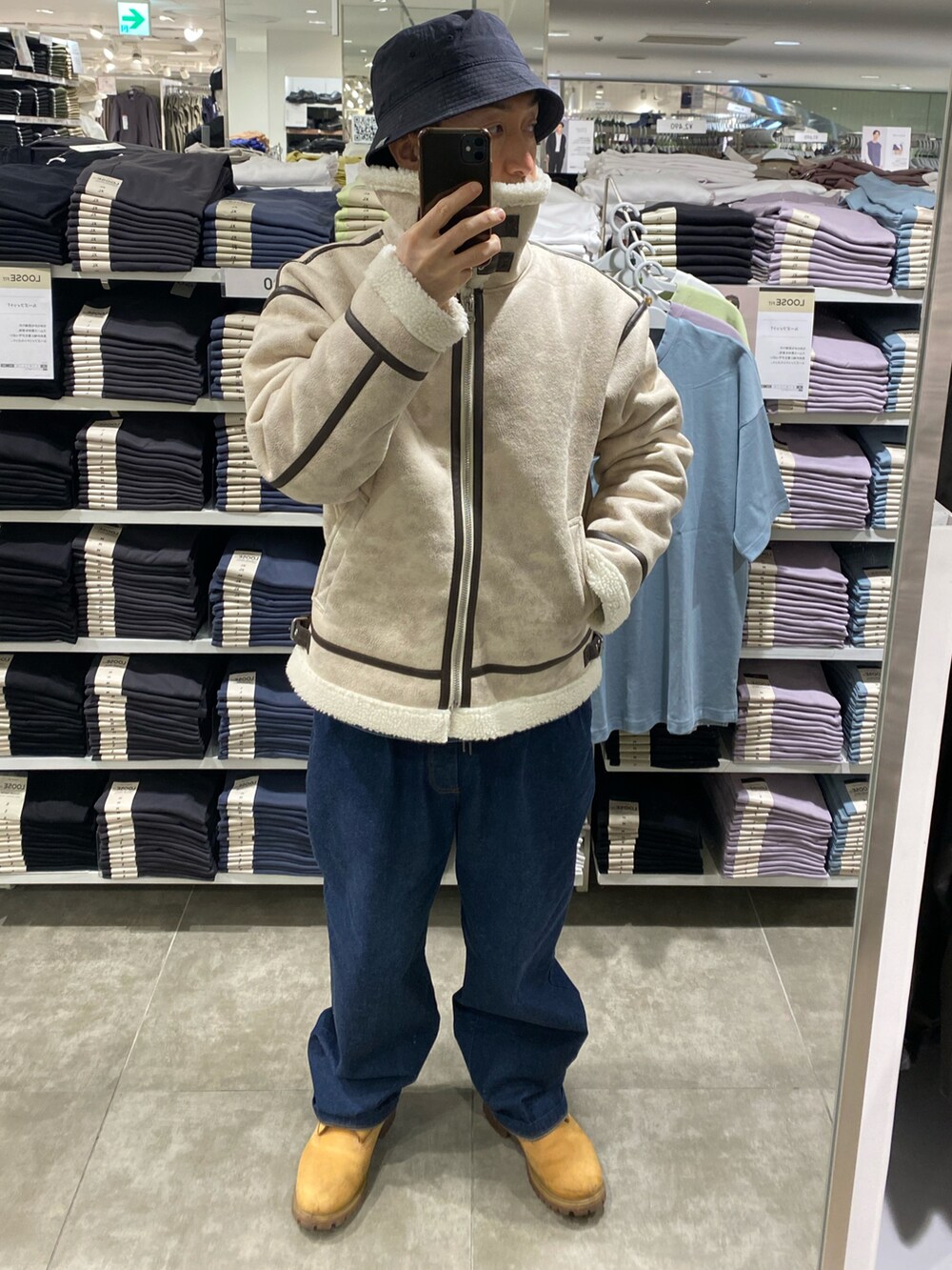 ホワイト系のブルゾン、ブルー系のデニムパンツ、ベージュ系のブーツを着用したメンズの冬コーディネートの3枚目の写真