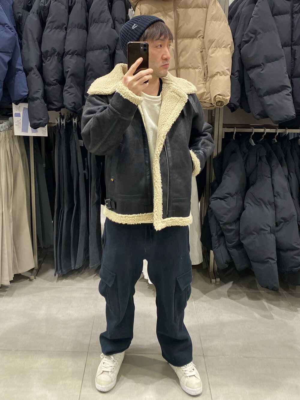 ブラック系のその他アウター、ホワイト系のスウェット、ブラック系のカーゴパンツを着用したメンズの冬コーディネートの2枚目の写真