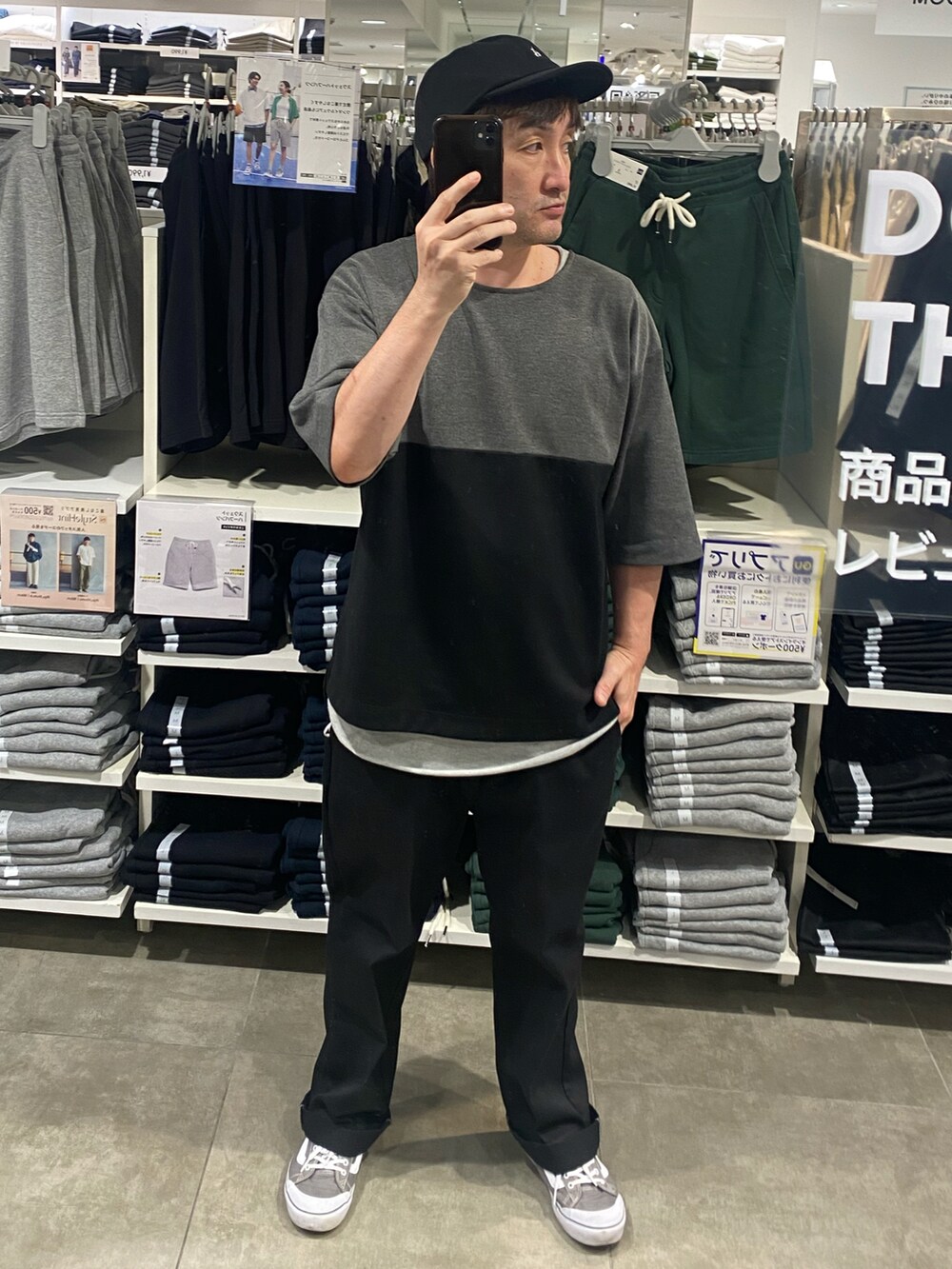 ブラック系のTシャツ/カットソー、ブラック系のチノパンツ、グレー系のスニーカーを着用したメンズの夏コーディネートの2枚目の写真
