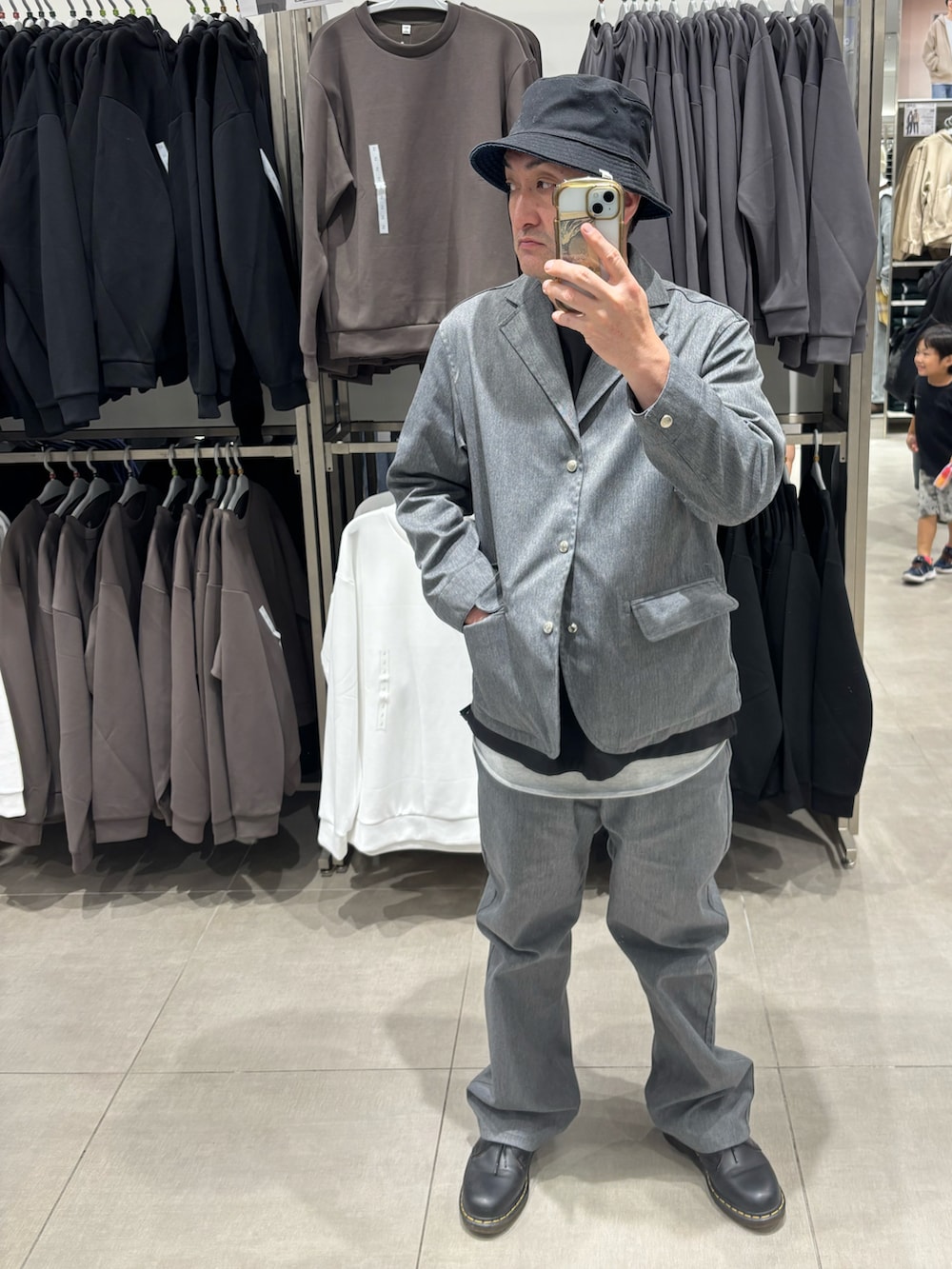 グレー系のテーラードジャケット、グレー系のチノパンツ、ブラック系のドレスシューズを着用したメンズの秋コーディネートの2枚目の写真